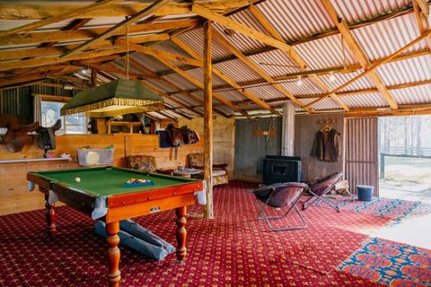 The games room with pool table under a rustic timber roof